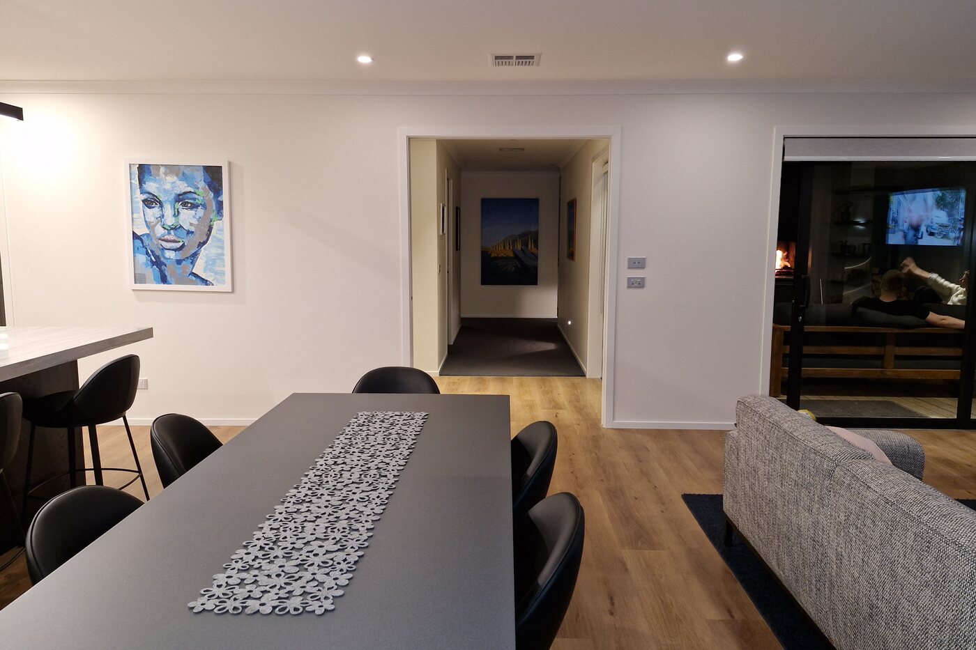 Open plan living and dining lit by recessed downlights, with power and data outlets through the room